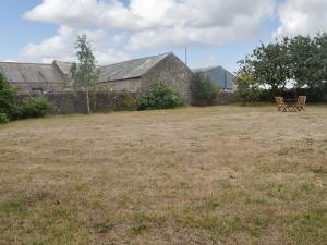 un banco sentado en un campo junto a un edificio en East Monkton Farm Cottage, en Wick