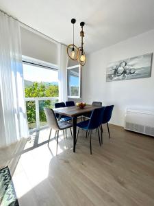 a dining room with a table and blue chairs at Blue Moon Guesthouse in Kamenicë