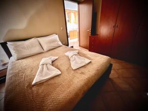 a bed with two white towels on top of it at CW Flat in Alexandroupoli
