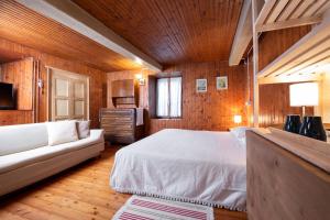 a bedroom with a white bed and a couch at B&B Casa Quaroni in Anzino