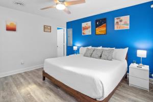 a bedroom with a white bed with a blue wall at Willapye Beach House by the Sea in Navarre