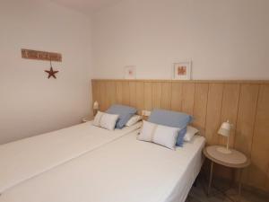 パラモスにあるPalamós Apartament Superior Garoinaのベッドルーム1室(ベッド2台、青と白の枕付)