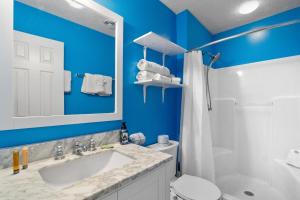 a bathroom with a white sink and a blue wall at Willapye Beach House by the Sea in Navarre +18 photos