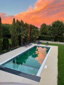 a swimming pool in a yard with a sunset at Apartment Veroeva in Rukavac