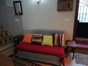 eine Couch mit Kissen darauf in einem Wohnzimmer in der Unterkunft Casa Vista in Alcalá de los Gazules