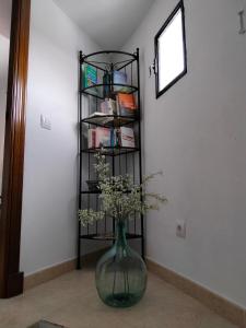 un jarrón con flores en una habitación con un estante en Casa Vista, en Alcalá de los Gazules