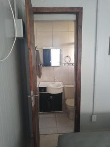 a small bathroom with a sink and a toilet at Kitbox PDR in Garopaba