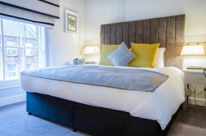 a bedroom with a large bed with yellow and blue pillows at Tulse Hill Hotel in London