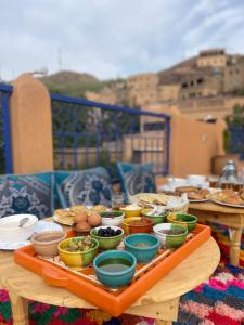 a table with bowls and plates of food on it at Riad otos views in Imlil