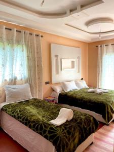 2 letti posti uno accanto all'altro in una camera da letto di Riad otos views a Imlil