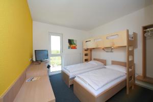 a bedroom with two bunk beds and a television at Tour-Motel in Wilfersdorf