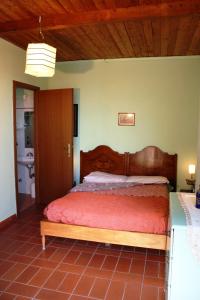 ピティリアーノにあるPoggio del Castagnoのベッドルーム1室(木製ヘッドボード付きのベッド1台付)