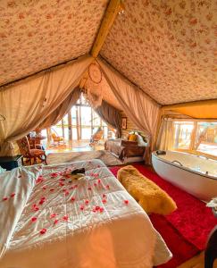 a bedroom with a bed and a tub in a tent at Tedesco Eco Park in São Francisco de Paula