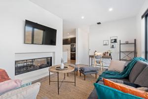 a living room with two couches and a fireplace at A Luckie Charm - 5-Bedroom Townhouse with Spectacular View in Queenstown
