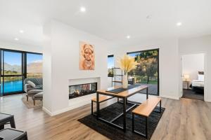a living room with a table and a fireplace at A Luckie Charm - 5-Bedroom Townhouse with Spectacular View in Queenstown