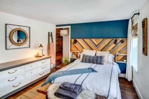 a bedroom with a large bed with a blue accent wall at Chic Troy Home Near Downtown, 9 Mi to Albany! in Troy