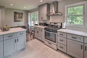 a kitchen with white cabinets and a stove top oven at Cozy Arden Cottage, 2 Mi to Lake Julian Park! in Arden