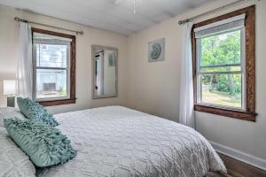 a bedroom with a bed and two windows at Cozy Arden Cottage, 2 Mi to Lake Julian Park! in Arden