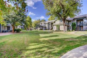 a house with a large yard with trees at Pet-Friendly Condo with Pool about 7 Mi to Dtwn Chandler in Chandler