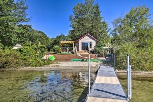 a house on the shore of a lake with a dock at Quaint Oakland Getaway on East Pond Lake! in Waterville
