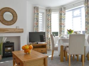 a living room with a dining table and a television at Westways in Bridlington