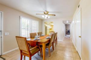 a dining room with a table and chairs and a ceiling fan at Spring into Oasis Permit# 5140 in Palm Springs