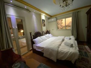 a bedroom with a large white bed with a window at Asma Pyramids View in Cairo