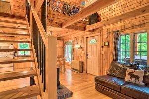 a living room with a staircase and a leather couch at Magnificent Victory Cabin with Private Hot Tub! 