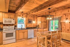 a kitchen with wooden cabinets and a table with chairs at Magnificent Victory Cabin with Private Hot Tub! 