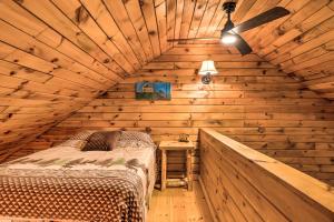 een slaapkamer met een bed in een houten hut bij Magnificent Victory Cabin with Private Hot Tub! 