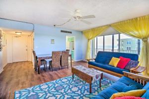 a living room with a blue couch and a table at Steps to Sand Satellite Beach Condo with Views! in Satellite Beach