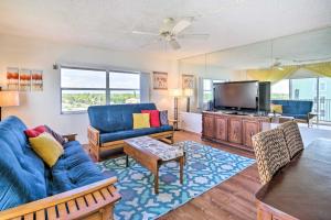 a living room with a blue couch and a tv at Steps to Sand Satellite Beach Condo with Views! in Satellite Beach