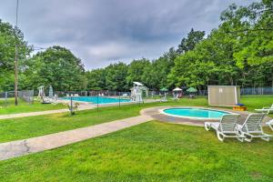 a swimming pool in a park with chairs in the grass at Game Room, Community Beach Pocono Home! in Albrightsville