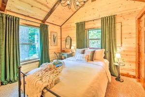 a bedroom with a bed in a log cabin at Rustic-Chic Woodland Hideaway with Hot Tub! in Sandpoint