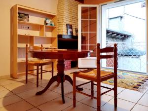 cocina con mesa, sillas y ventana en Appartement au calme au cœur du village, en Saint-Beauzély