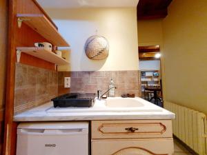 - une cuisine avec un évier et un bol sur le mur dans l'établissement Logement entier Chez Léa et Brevia, à Saint-Beauzély 12 autres photos