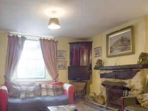 a living room with a couch and a fireplace at Doward Farm in Symonds Yat