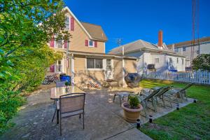 a yard with chairs and a table and a house at Nautical Wildwood Apt - Walk to the Beach! in Wildwood