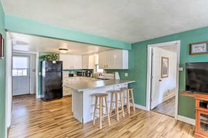 a kitchen with green walls and a kitchen island with bar stools at Pet-Friendly Pierre Home with Central Location! in Pierre