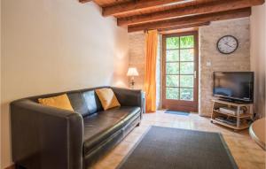 a living room with a leather couch and a tv at Wisteria in Nanclars