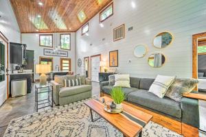 a living room with a couch and a table at Chic Broken Bow Cabin with Hot Tub and Gas Grill! in Broken Bow