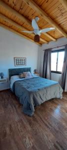 a bedroom with a bed with a ceiling fan at Pequeña Polonia-Lodge & Cabañas in Los Reartes