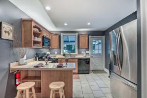 a kitchen with a stainless steel refrigerator and wooden cabinets at Charming Lambertville Retreat - 1 Mi to River! in Lambertville