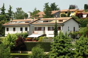 una grande casa bianca con alberi di fronte di villa ginestra a Negrar