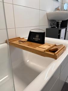 einen Laptop auf einem Holzregal in einer Badewanne in der Unterkunft Casa qui Roetgen in Roetgen