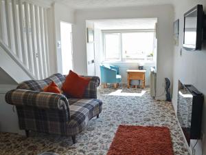 a living room with a couch and a table at Seascape in Balintore