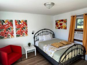 1 dormitorio con 1 cama y 1 silla roja en Cobmin Ridge Motel, 
