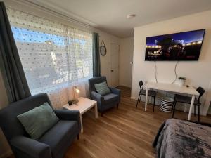 a bedroom with a couch and a table and a desk at Cobmin Ridge Motel 