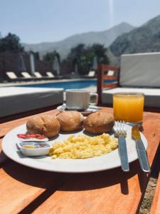 un plato de comida con galletas y huevos y un vaso de zumo de naranja en HOTEL MAR Y LAGO, en Lunahuaná