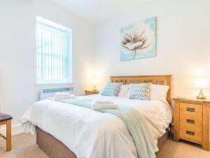 a bedroom with a bed and two lamps and a window at Claro Cottage - Uk37450 in Pateley Bridge
